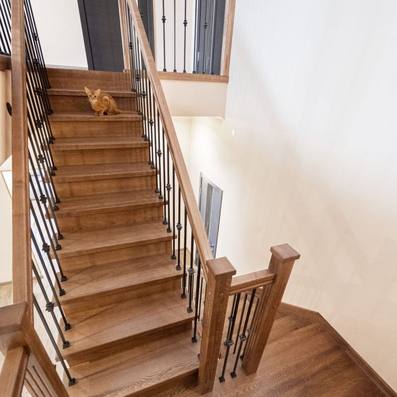 Обшивка металлокаркаса лестницы дубом с ограждением из металла